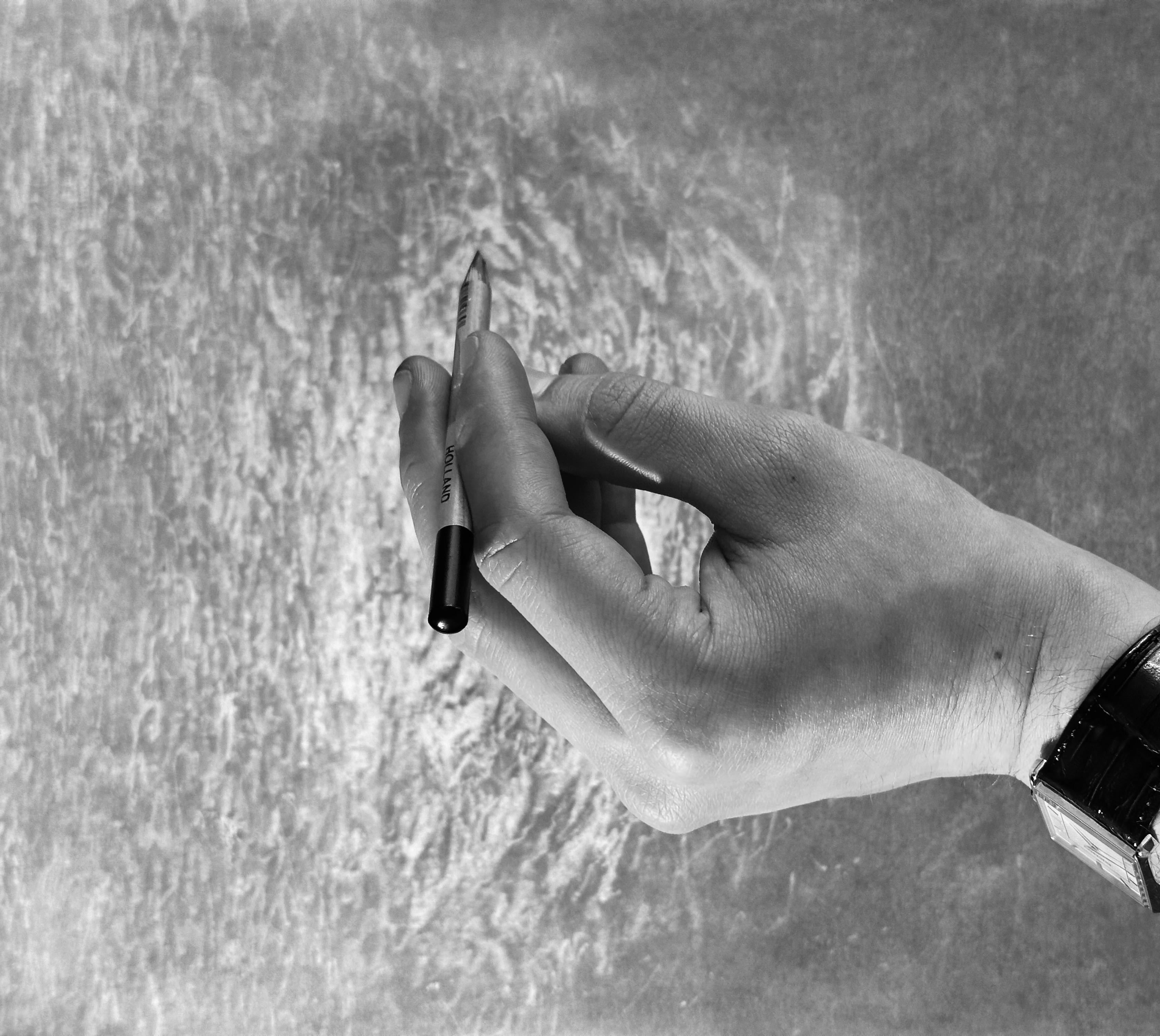 Hand holding a pen over a textured surface